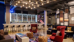 Ein moderner Lounge-Bereich mit Bar, Sitzgelegenheiten und einem gemusterten Teppich.