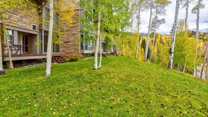 A modern building with a stone facade and a grassy lawn.