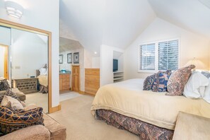 A bedroom with a large bed, a dresser, a mirror, and a window with blinds. - Ideal Location- 3 BDR Mountain Village Townhome Steps from Skiing (Mountain Village)