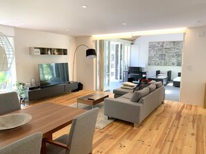 Relax in this stylish living room with a large flat-screen TV, comfortable sofa, and dining area.