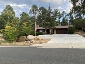 A residential house with a driveway, a mailbox, and a flagpole.