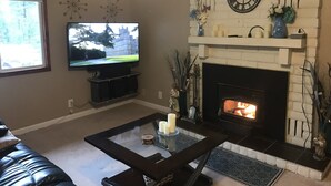 A living room with a fireplace, a television, and a coffee table. - Single Story Chic' One mile from Downtown,  with Tesla 220v Outlet in Garage (Prescott)