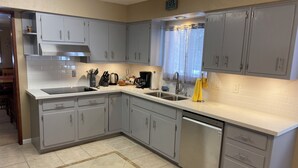 A modern kitchen with grey cabinets, a stainless steel sink, and a dishwasher. - Single Story Chic' One mile from Downtown,  with Tesla 220v Outlet in Garage (Prescott)