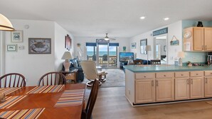 A spacious kitchen with a large island, wooden cabinets, and a view to the beach. - "All Good" Oceanfront 2 bedrooms, 2 bathrooms. (Holden Beach)