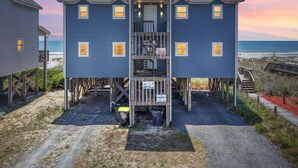 A two-story beachfront house with a balcony, a wooden staircase, and a beach view. - "All Good" Oceanfront 2 bedrooms, 2 bathrooms. (Holden Beach)