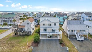 Ein Küstenwohngebiet mit mehreren zweistöckigen Häusern, die Erker und eine markante Treppe zum Obergeschoss haben.