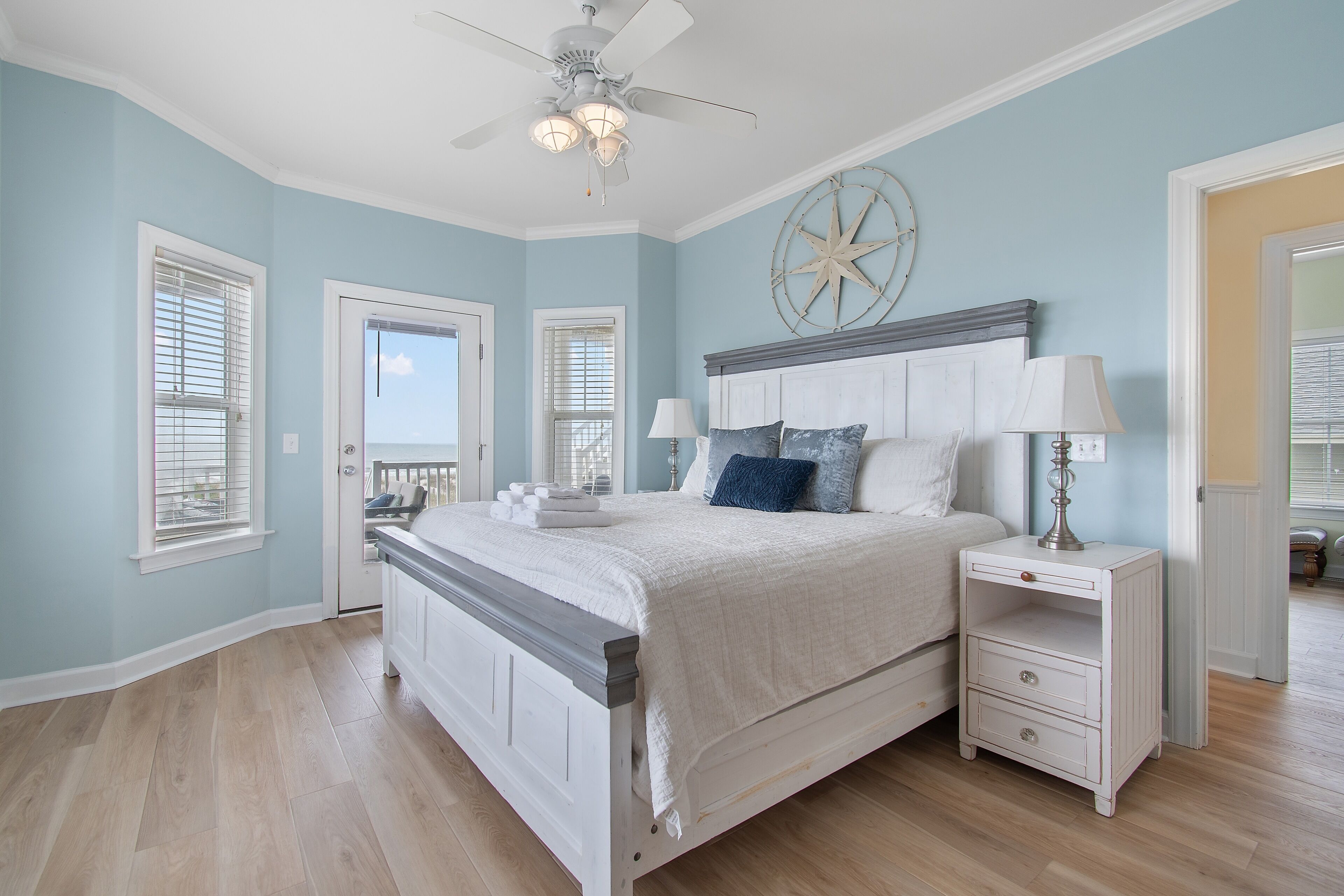 A bedroom with a bed, nightstands, a ceiling fan, and a star wall decoration.
