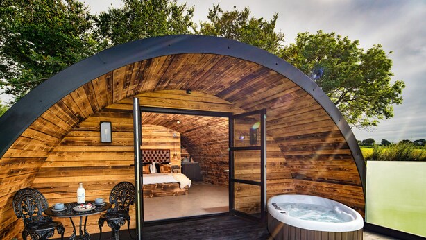 A cozy wooden cabin with a private bathroom, a dining area, and a hot tub.