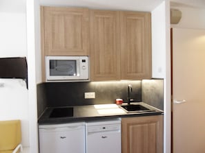 A compact kitchen with a microwave, a sink, and two dishwashers.