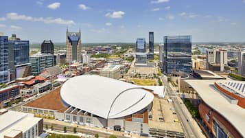 Un paysage urbain moderne avec un grand stade, des immeubles de grande hauteur et un mélange de bâtiments commerciaux et résidentiels.