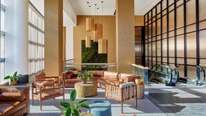 A modern lobby with leather sofas, wooden accents, and a green wall. - Embassy Suites by Hilton Nashville Downtown (Nashville)