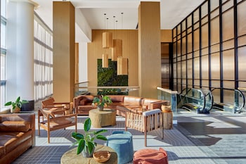 A modern kitchen with a wood panel backsplash, built-in appliances, and a dining area with a table and chair. at Embassy Suites by Hilton Nashville Downtown