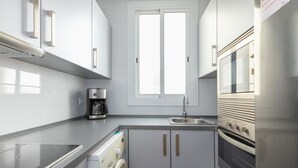 A modern kitchen with a built-in washer, oven, and microwave. - Casa Flors - 2 bedroom apartment with free wifi (Barcelona)