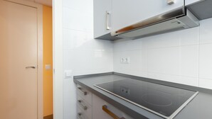 A modern kitchen with white cabinets, a black countertop, and a built-in stove. - Casa Flors - 2 bedroom apartment with free wifi (Barcelona)