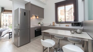 A modern kitchen with a stainless steel refrigerator, a microwave, and a sink. There is a window with a view of buildings outside. - Gaudí Views- Suite with view on Hospital Sant Pau (UNESCO Heritage)  - FREE WIFI (Barcelona)