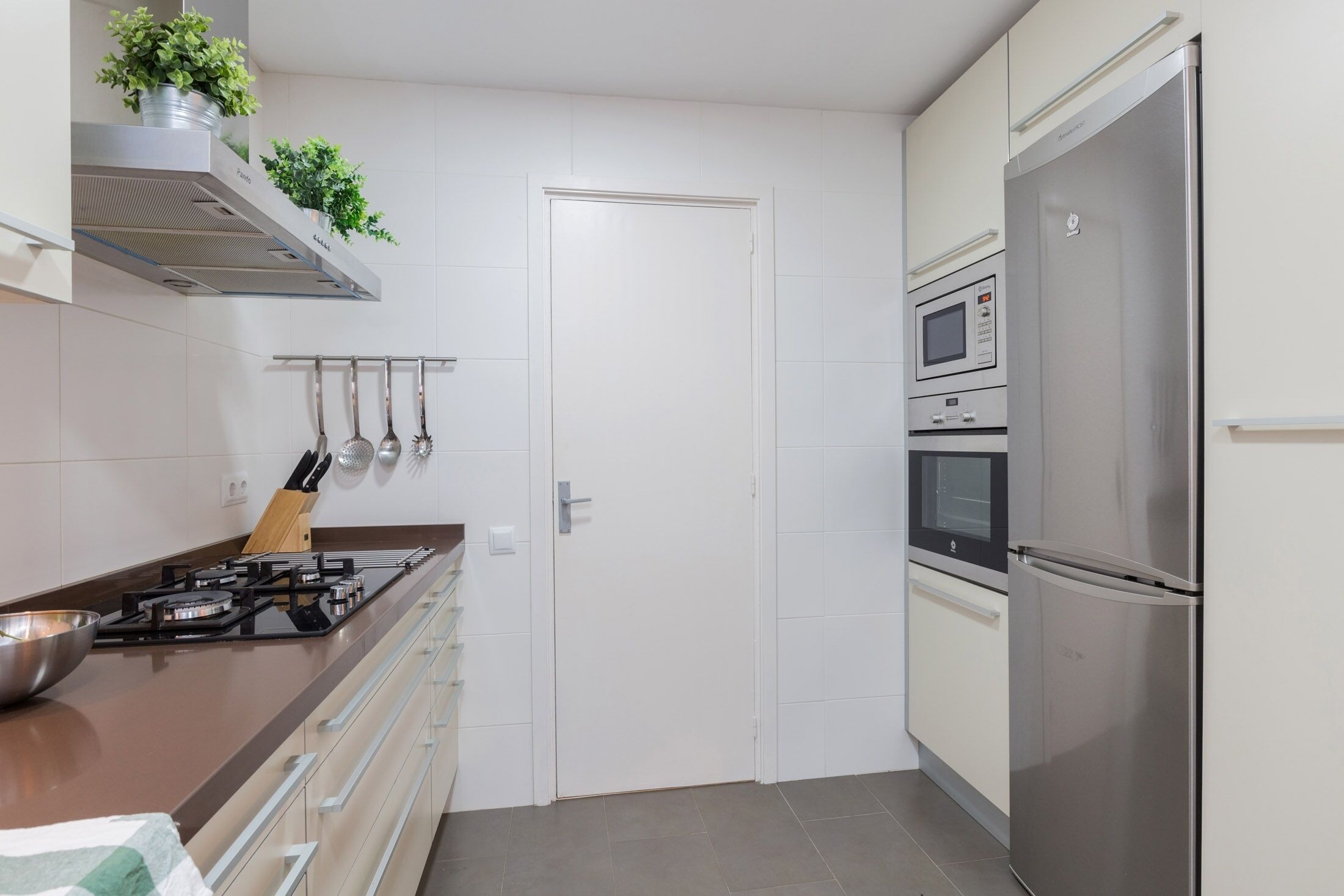 A modern kitchen with a gas stove, stainless steel appliances, and a microwave.