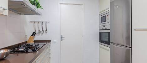 A modern kitchen with a gas stove, stainless steel appliances, and a microwave.