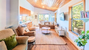 A cozy living room with a wooden ceiling, a sofa set, a coffee table, and a bookshelf. - Serenity in the Pines: Cozy Mountain Retreat (Twain Harte)