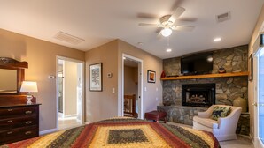 A bedroom with a large bed, a fireplace, a television, and a ceiling fan. - Blue Ridge Blessing - Pet Friendly! Views, hot tub, great location on App Ski Mtn! (Blowing Rock)
