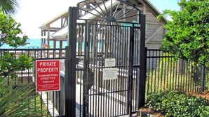 A gated entrance to a private property with a sign indicating 'PRIVATE PROPERTY' and 'Armband Policy Strictly Enforced'. - 23 Aquamarine • Private Beach Access • Golf Cart • 2 Pools • Beach Gear • Tennis (Destin)