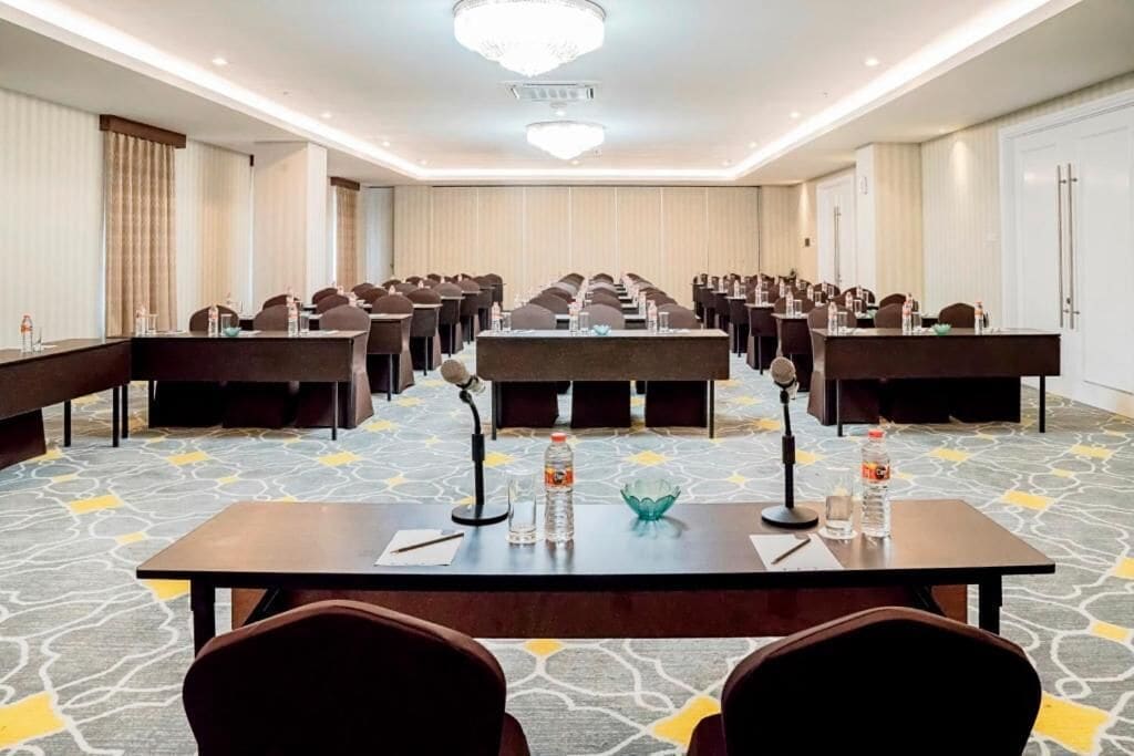 A conference room with a long table, multiple chairs, and a carpeted floor.