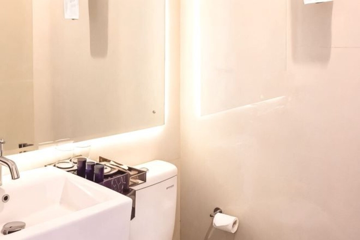 A bathroom with a sink, mirror, and toilet.