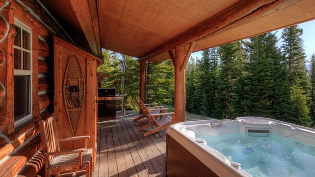 A wooden deck with a hot tub and outdoor seating.