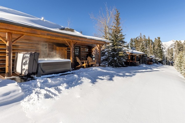 View of groomed ski slope with this cabin's front porch/hot tub