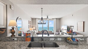 A kitchen with granite countertops, a double sink, and a ceiling fan. - Majestic Sun B613*Remodeled* Gulf Views*Beach Gear*Hot Tubs/Heated Pools* Tennis (Miramar Beach)
