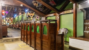 A traditional interior with wooden benches and green glass windows. - Treebo Bhairavee, Baner (Pune)