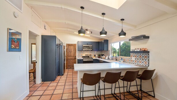 A modern kitchen with a central island, bar stools, and pendant lighting. - Remodeled, Centrally Located in Sedona 2 Bed / 2 Bath Home (Sedona)