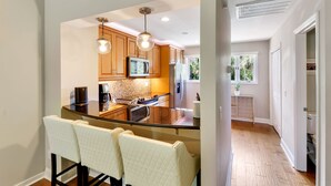Una cocina moderna con armarios de madera, una isla central e iluminación colgante.