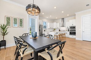 A modern kitchen with white cabinets, stainless steel appliances, and a central island with seating.