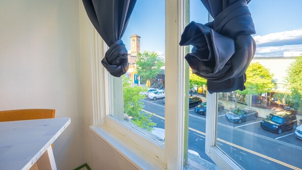 A room with a window overlooking a street, a table, and a chair. - Downtown City Condo (Tacoma)