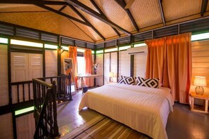 Ein Schlafzimmer mit einem Bett, einem Schreibtisch, einem Stuhl und einem Fenster mit Vorhängen.