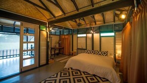 Un dormitorio con cama, ventana, puerta y ventilador de techo.