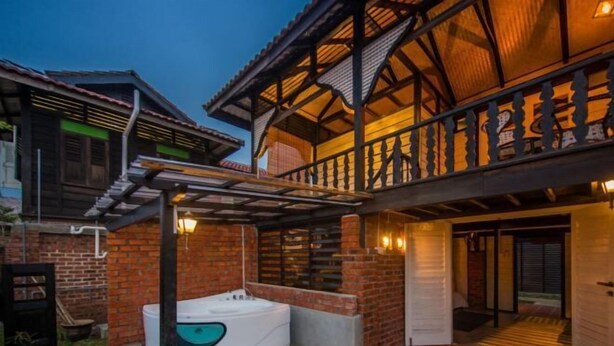 Una casa de dos pisos con balcón, jacuzzi y fachada de ladrillo.