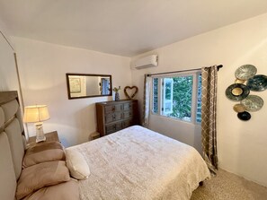 A bedroom with a bed, dresser, mirror, and decorative items. - Ocean View Apt with Jacuzzi and Terrance in Playa Santa (Guanica)