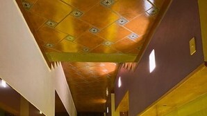 A narrow hallway with a patterned ceiling and walls painted in yellow and purple. - Finca El Paraiso  (Tepoztlán)