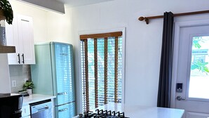 Een compacte keuken met een centraal eiland, een inbouwfornuis en een bank.