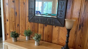 Una pared de madera con un espejo enmarcado por las palabras 'LIVE LOVE LAUGH'.