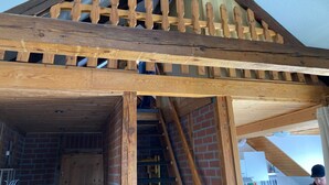 Una escala de fusta amb barana de fusta que condueix a una zona en alt.