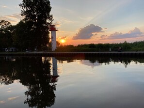 A calm lake reflecting a lighthouse and sunset. - Vacation apartment on the Szczecin Lagoon with garden and terrace (Ueckermünde)