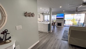 A spacious living area with a kitchen, a fireplace, and a balcony with a view.