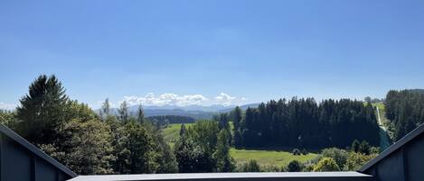 A view from a balcony overlooking a mountainous landscape with a clear sky.