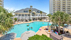 A large swimming pool surrounded by lounge chairs and umbrellas, with a multi-story building in the background. - Beach Front Penthouse 4 Top Floor! K/K/K/K/tw/tw-Ocean Front 70 ft Balcony-Pools (Gulf Shores)