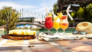 A table with drinks, a pineapple, and a straw hat. - Hotel Rancho Leon a Place to Stay | Room 12 (Quepos)
