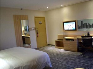 Relax in this spacious room with a large bed, a desk with sink and mirror, and a flat-screen TV.