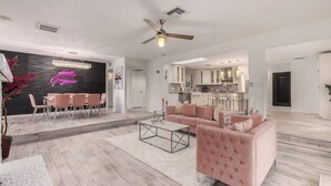 A spacious living area with a modern kitchen, a dining area, and a seating area with a pink sofa. - Love Oasis II - Scottsdale Beach Club NEW (Scottsdale)