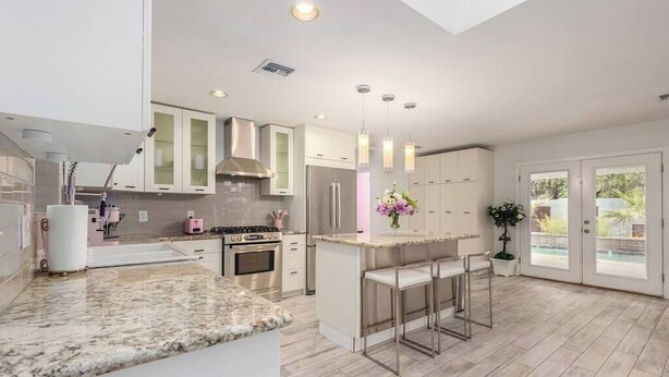 A modern kitchen with a marble countertop, stainless steel appliances, and pendant lighting. - Love Oasis II - Scottsdale Beach Club NEW (Scottsdale)